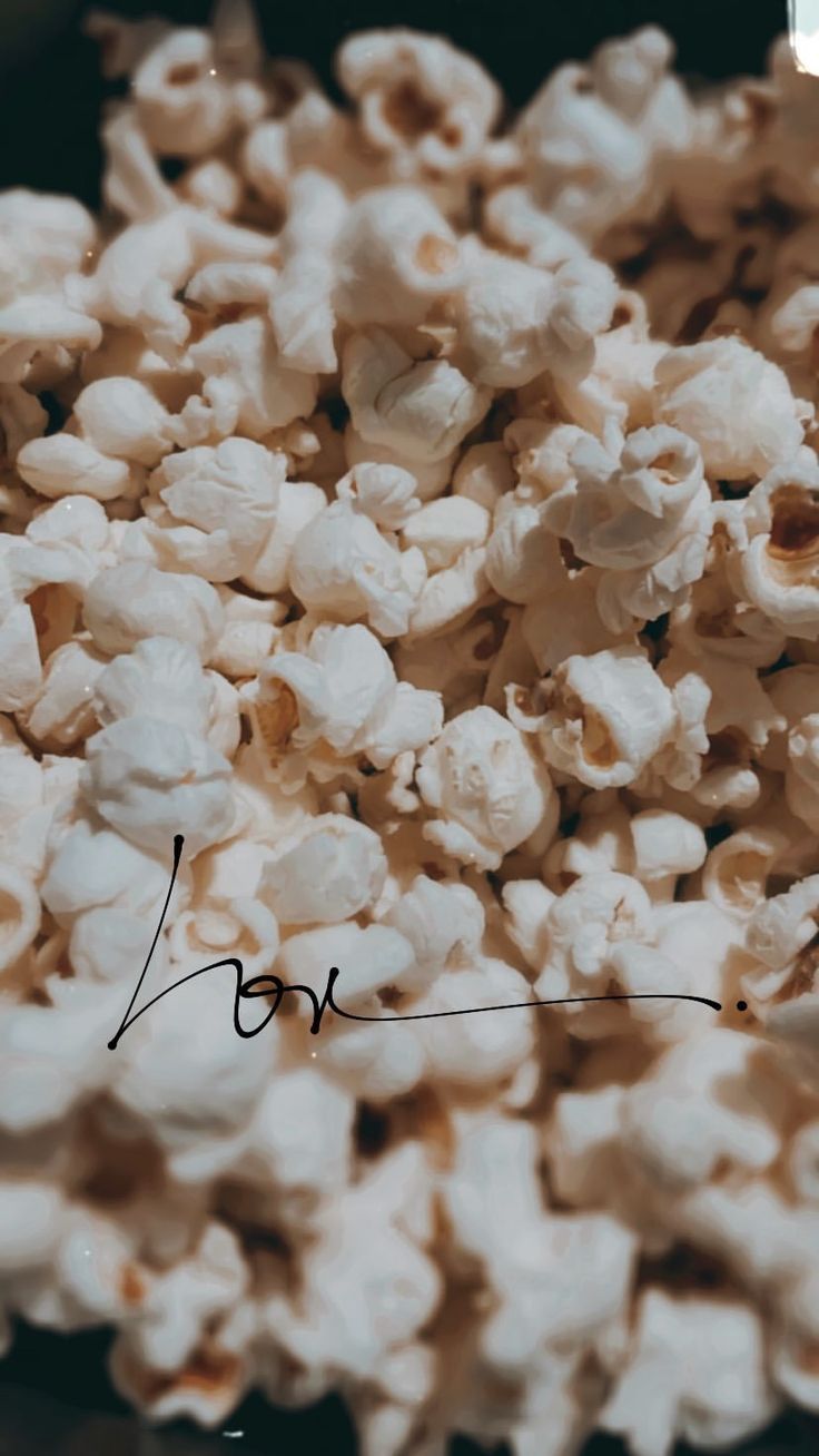 A close up of popcorn with the word 'now' written underneath. - Popcorn