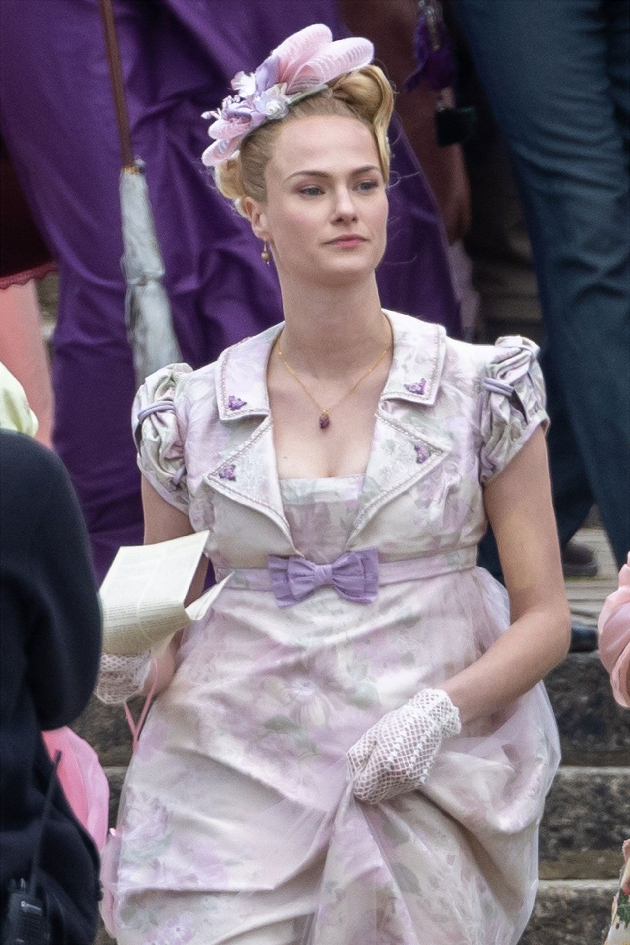 Elle Fanning as a 19th century woman in a pink dress with a flower in her hair - Bridgerton