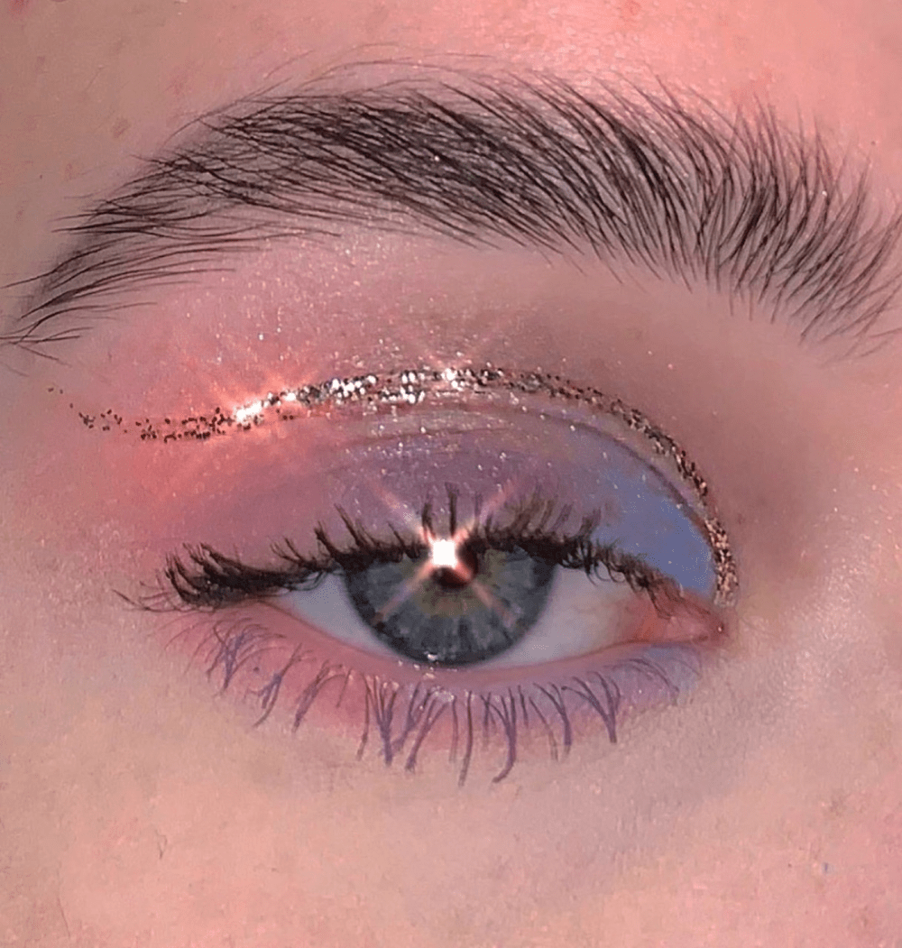 A close up of a human eye with pink and blue eyeshadow - Makeup