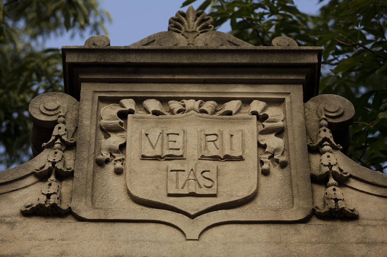A stone crest on a building at Harvard University, which is pictured in a file photo. - Harvard