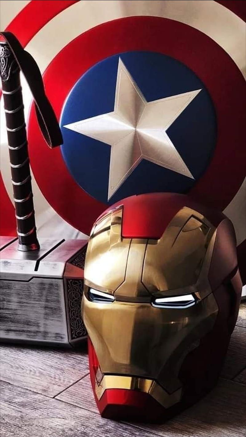 Iron Man Helmet, Captain America Shield and Thor's Hammer on a wooden floor - Captain America