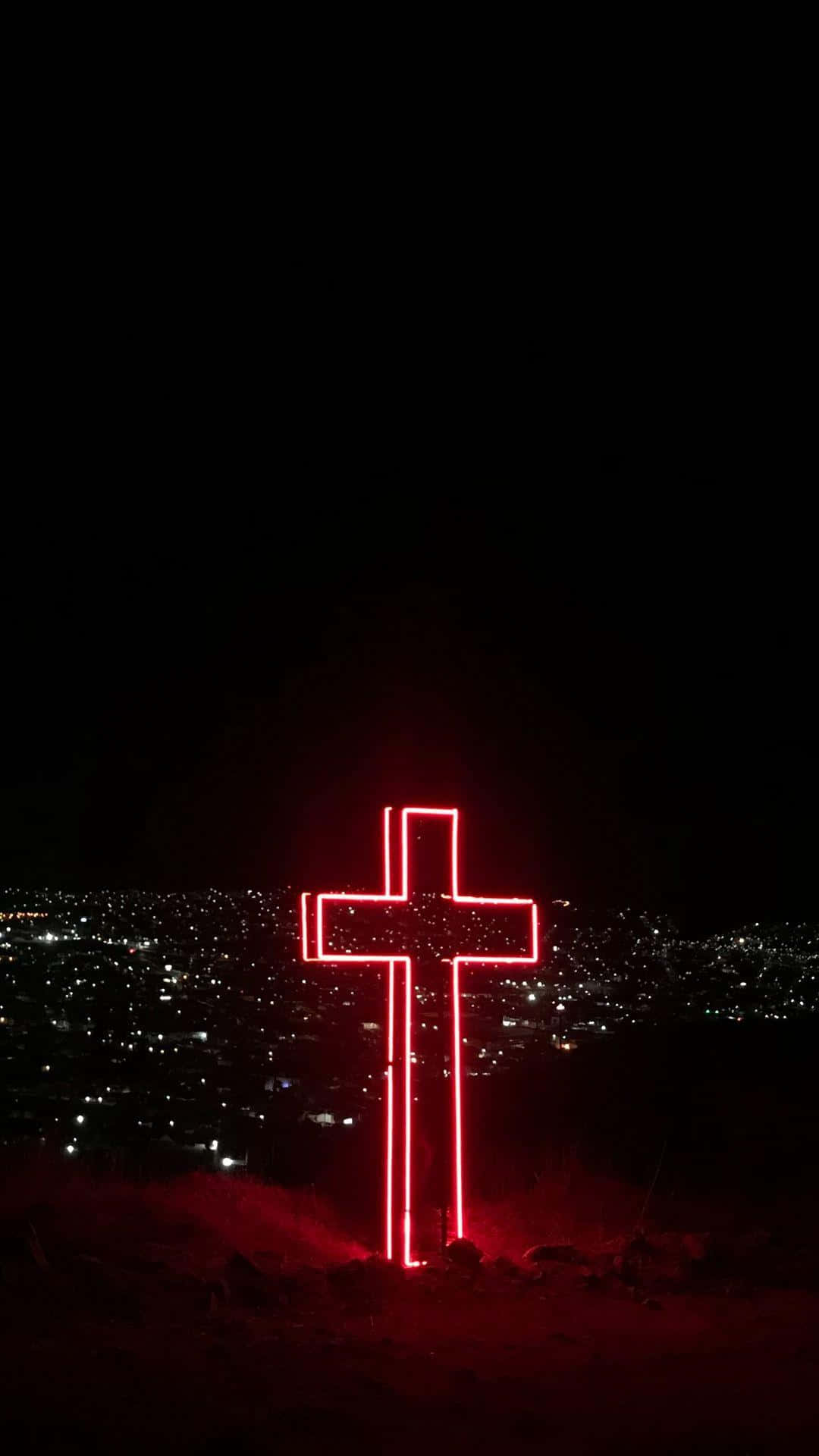 A red neon cross on a hill at night. - Cross