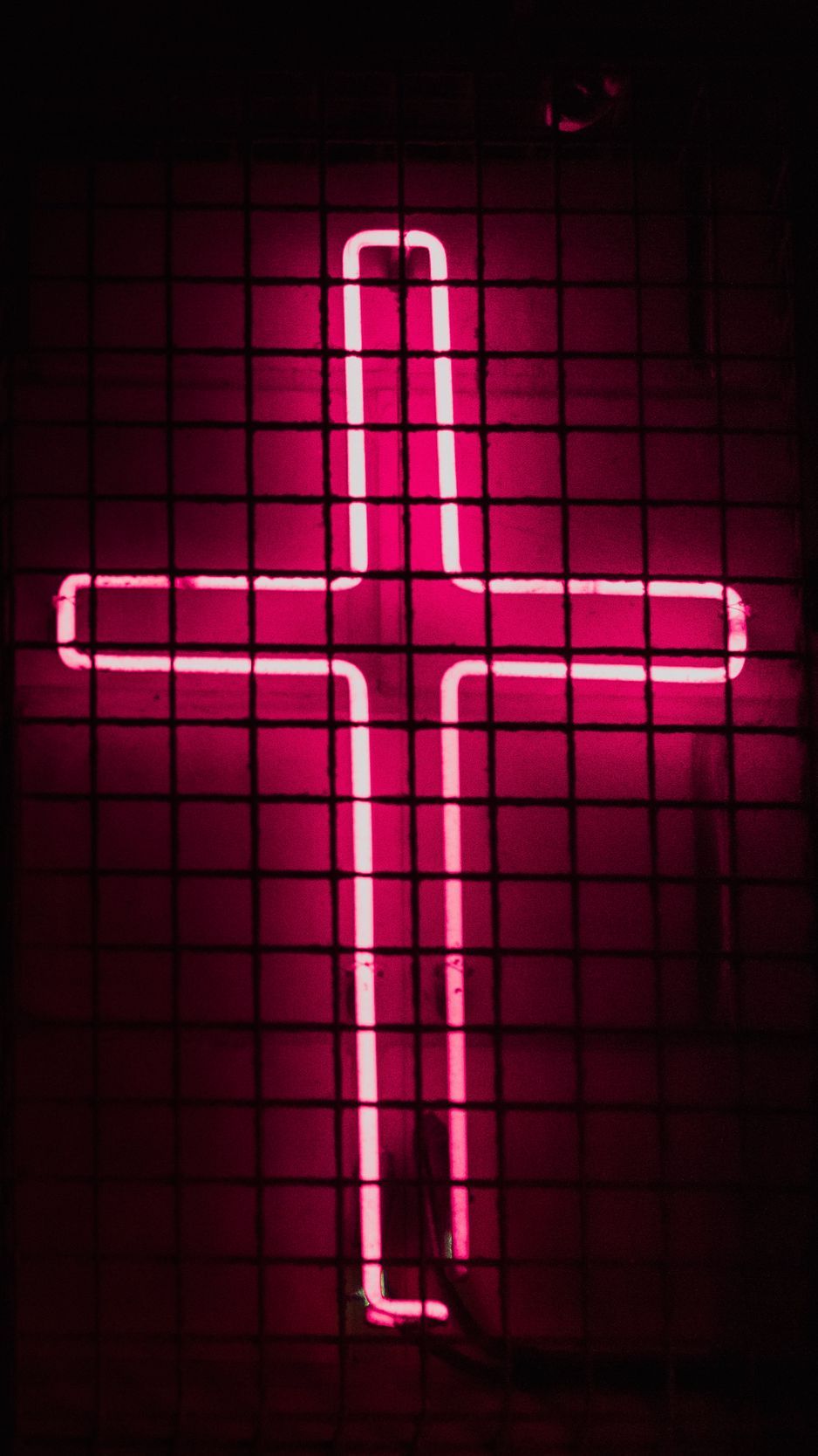 A pink neon cross on a black background - Cross