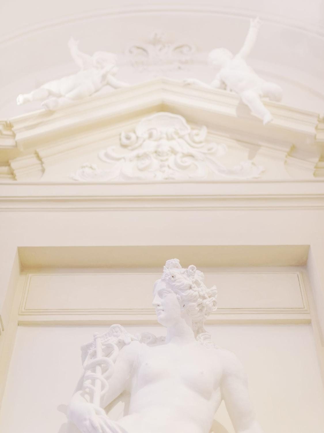 A white statue of a woman in a white room - Greek statue