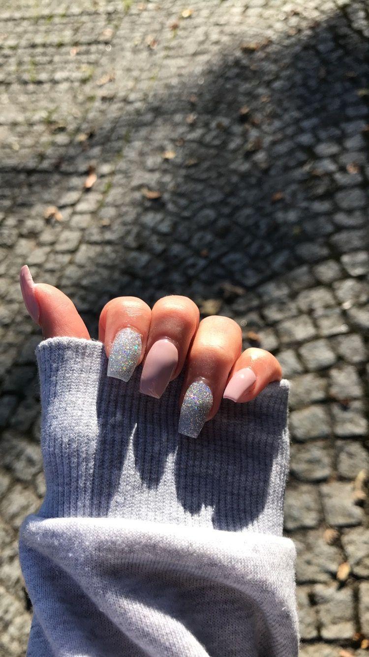 A woman's hand with a white and silver glittery nail - Nails