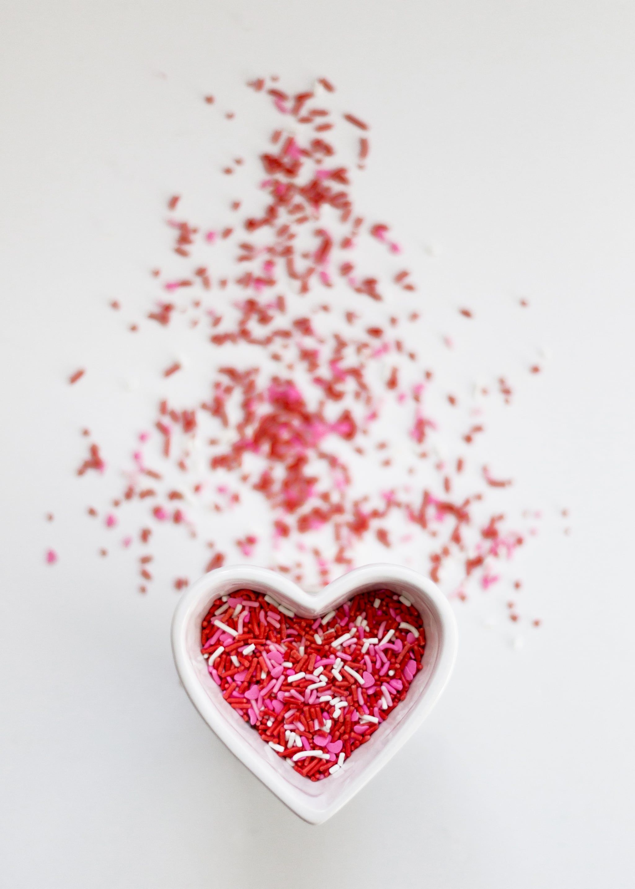 A heart shaped bowl with red and pink sprinkeled in it - Valentine's Day