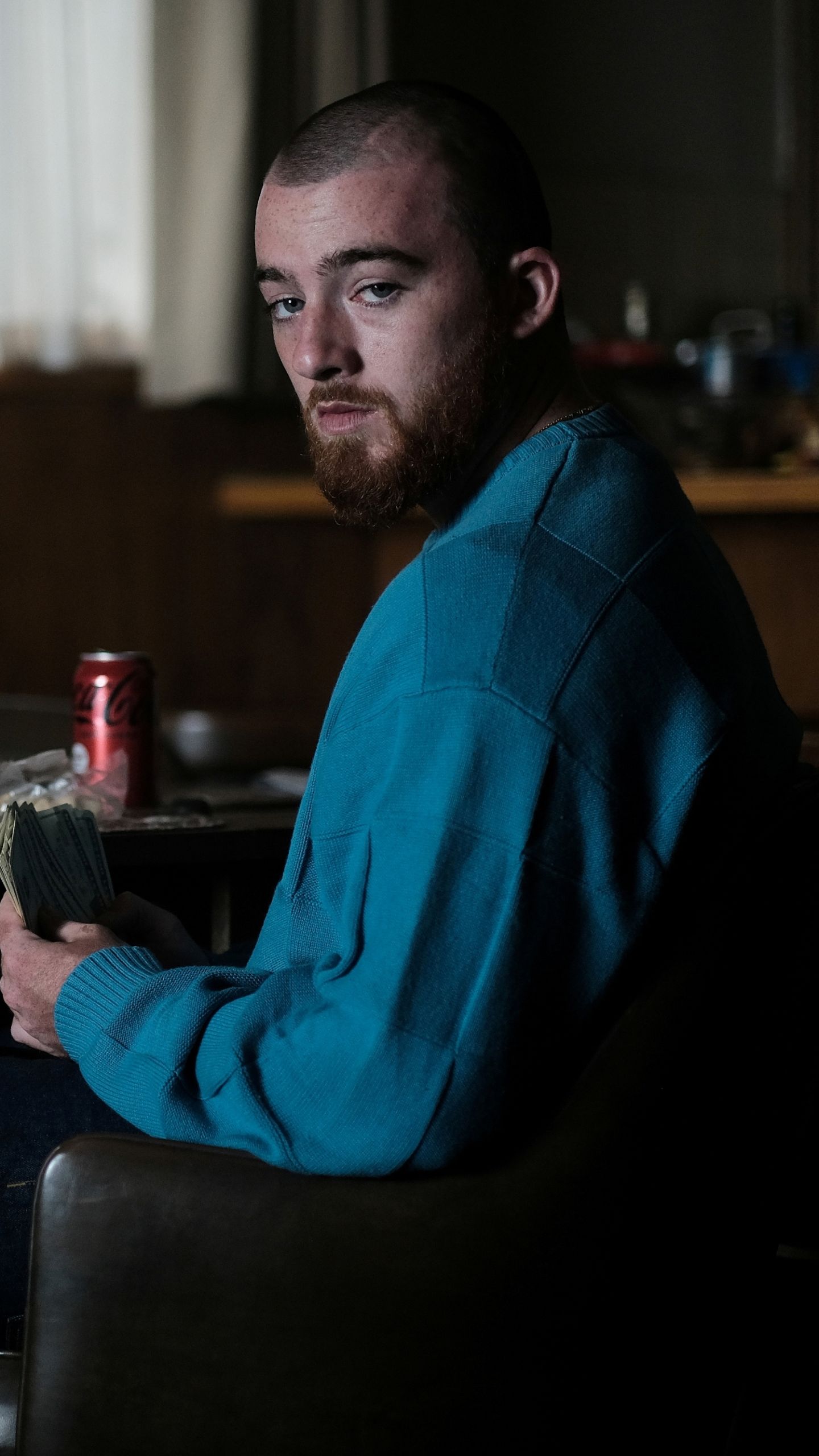 Mac Miller in a blue sweater holding a wad of money - Angus Cloud