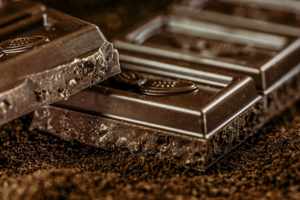 Close-up of dark chocolate bars on a brown surface. - Chocolate