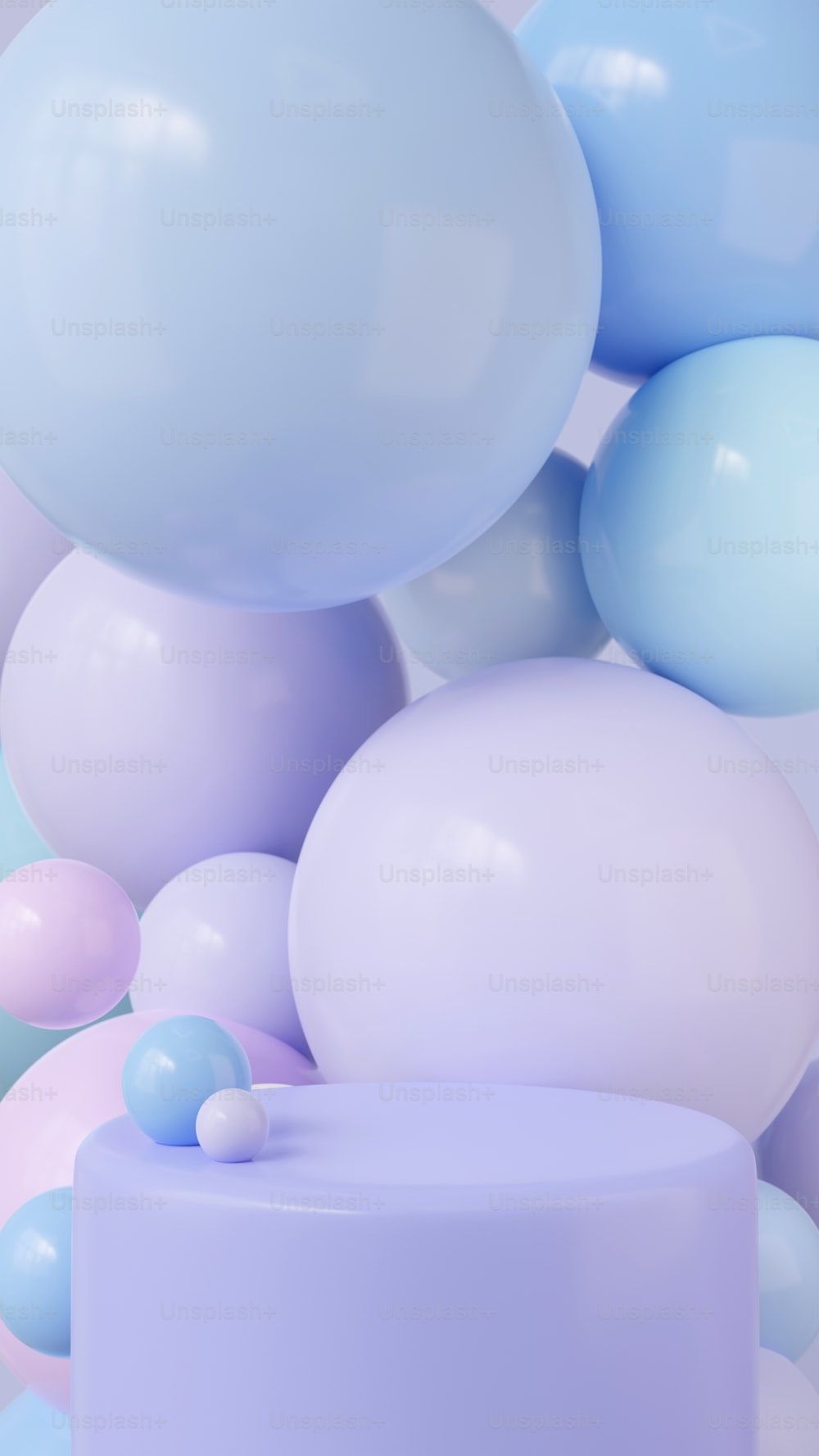 A white cake with blue and pink balloons in the background photo