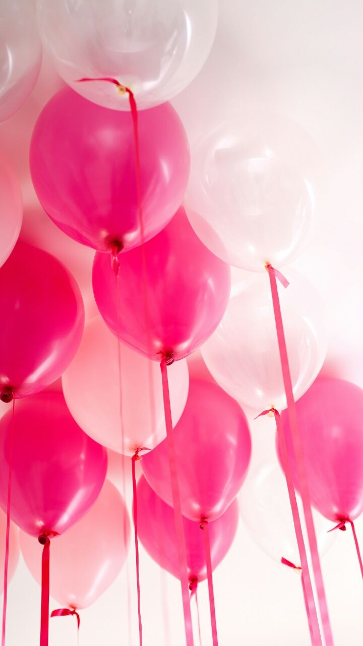 A bunch of pink and white balloons floating in the air. - Balloons