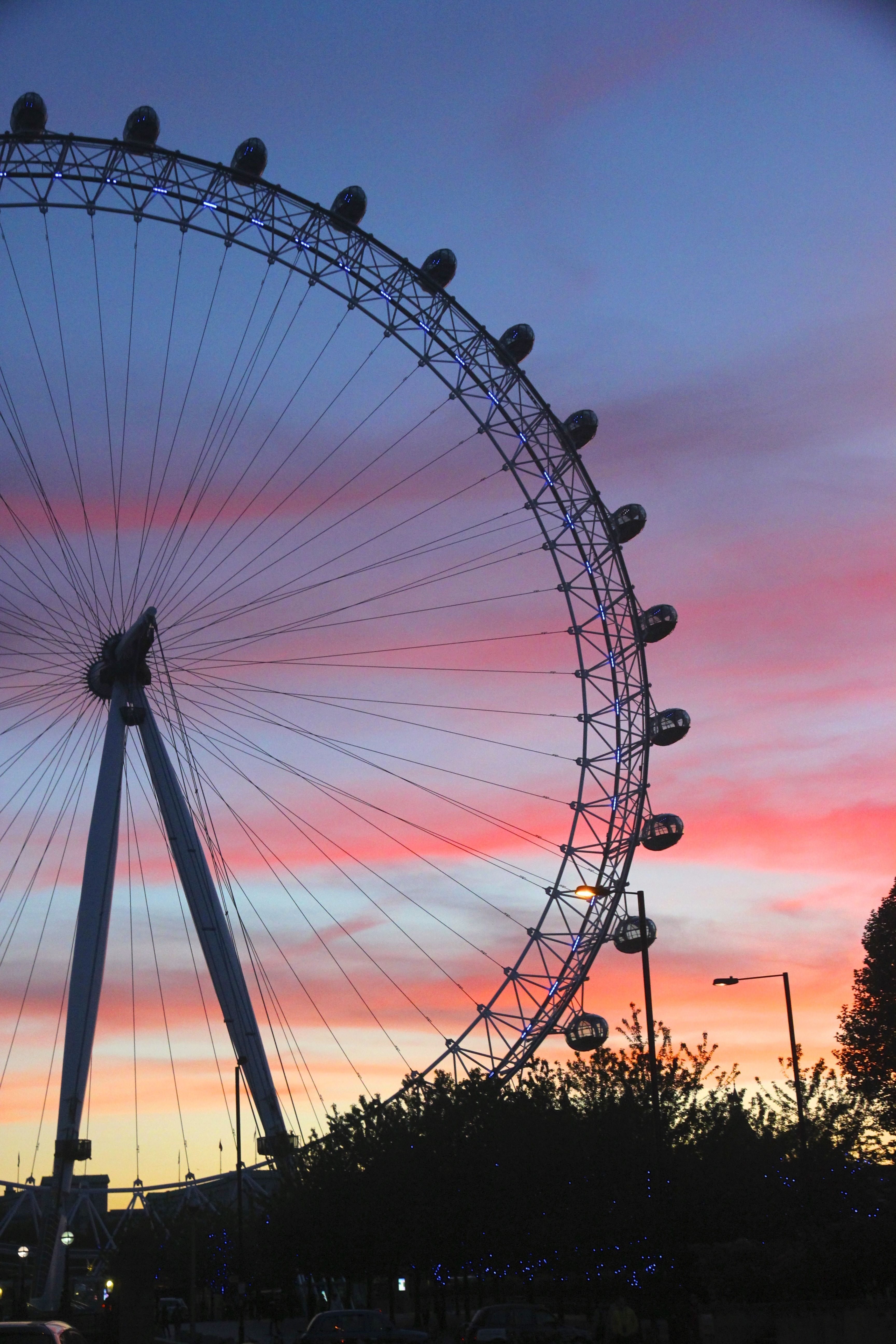 A large ferris wheel against a blue and pink sky - London