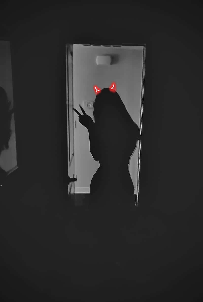 A woman's silhouette in a doorway with red horns - Shadow