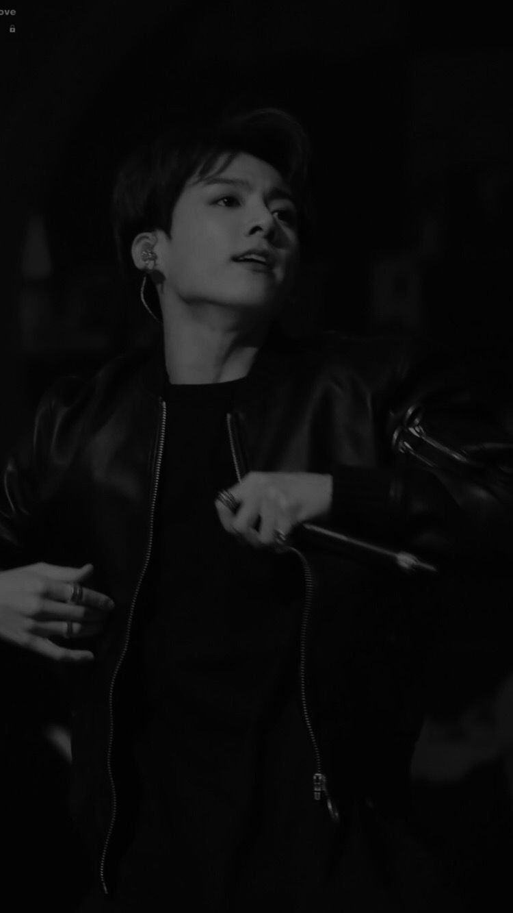 A black and white photo of a person sitting down - Jungkook