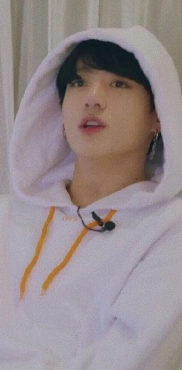 A person wearing a white hoodie with a white curtain behind them - Jungkook