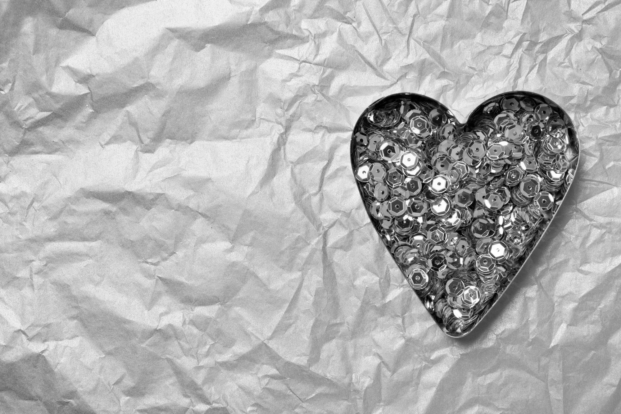 A heart made out of buttons on a crumpled piece of paper - Bling