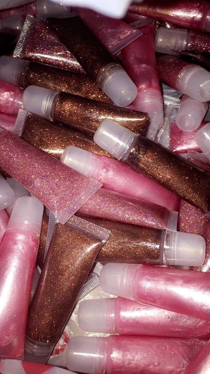 A pile of lip glosses with pink and brown glitter. - Glossy