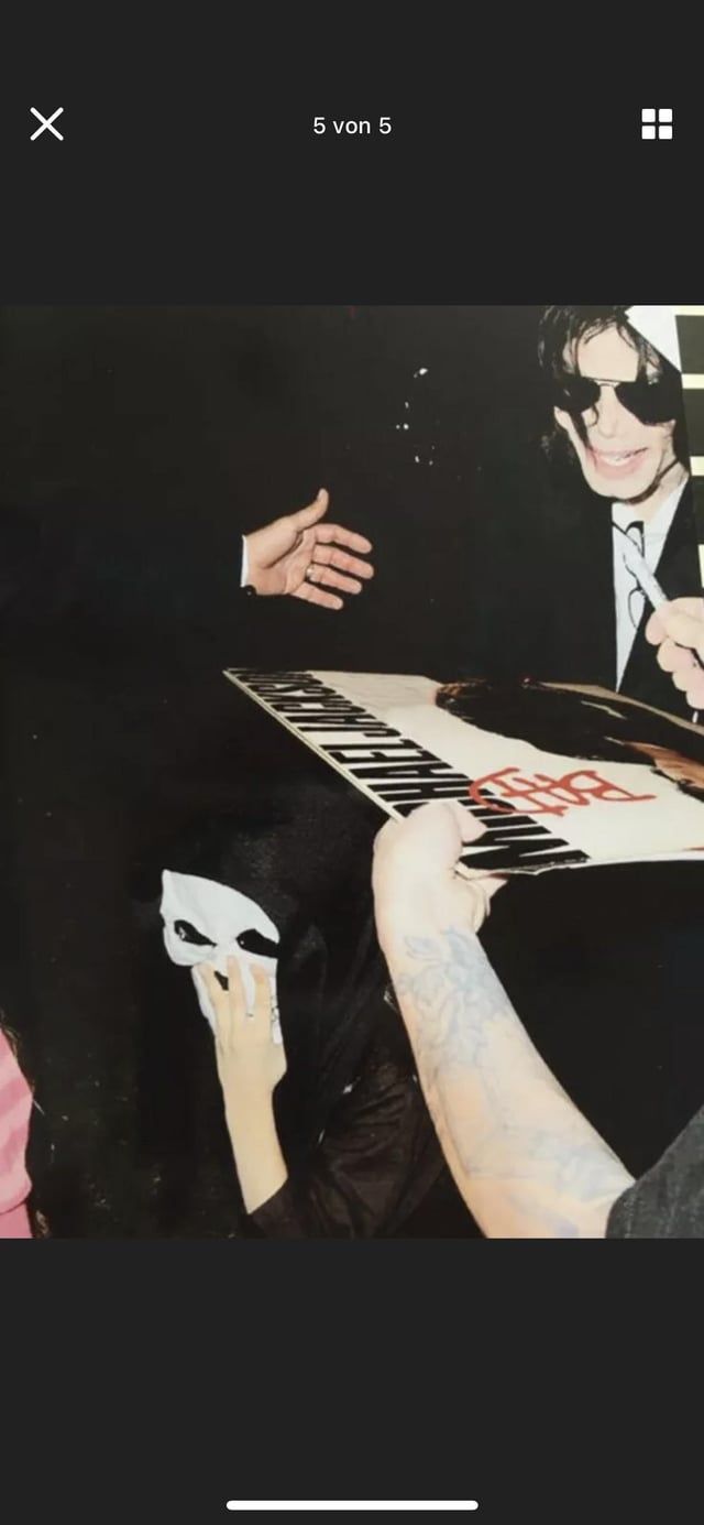 A person holding a keyboard in front of a man. - Michael Jackson