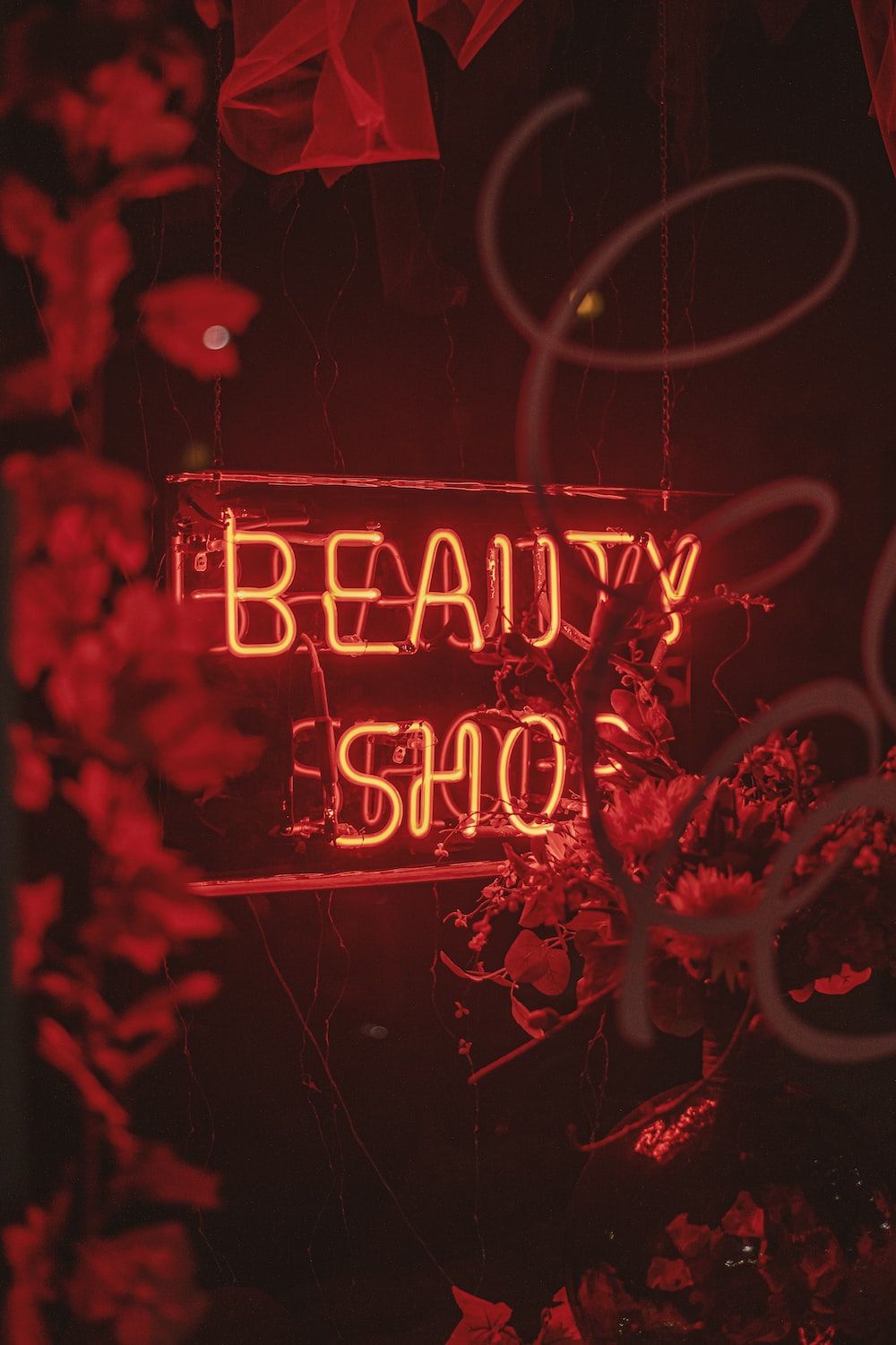 A red neon sign that says beauty shop photo