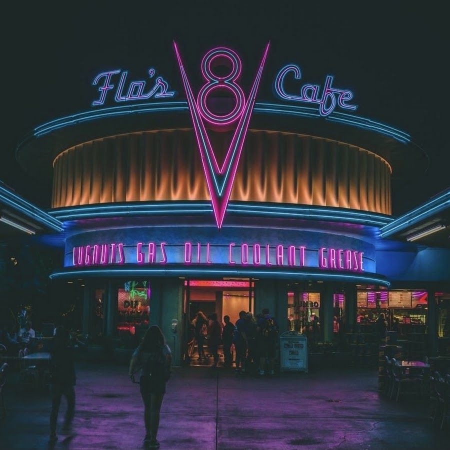 The neon lights of Flats 8 Cafe are glowing bright at night. - Disneyland