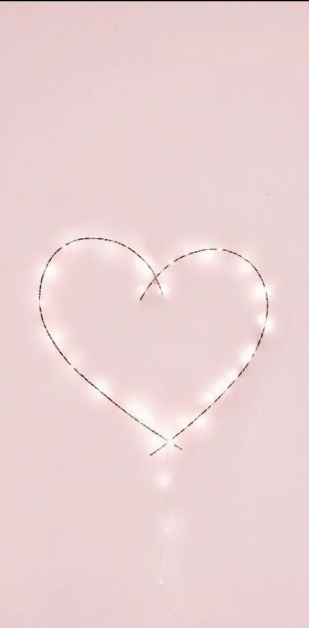 A heart made out of fairy lights on a pink background - Pink heart