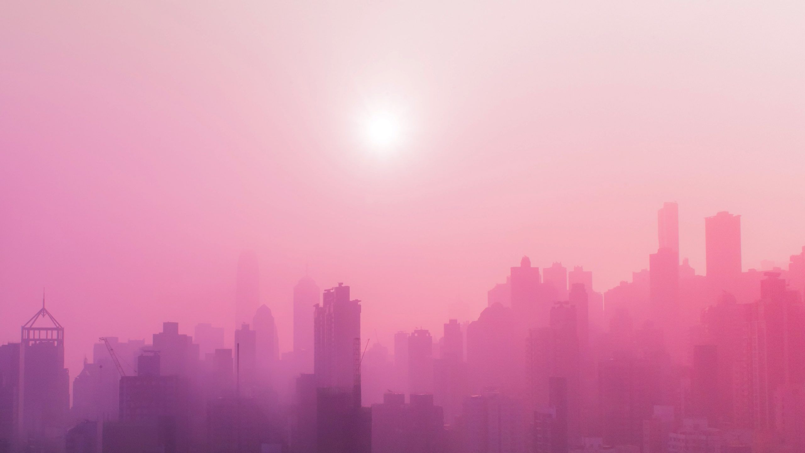 A city skyline is shown in a pink and purple hue. - Fog
