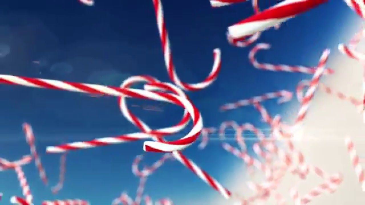 Red and white candy canes floating in the air against a blue sky. - Candy cane