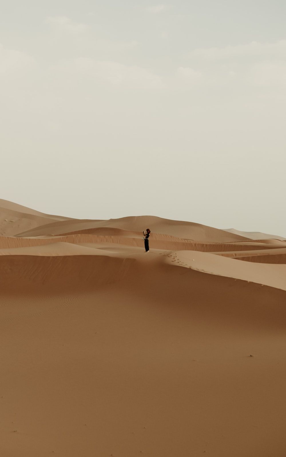 A woman standing in the middle of the desert - Desert