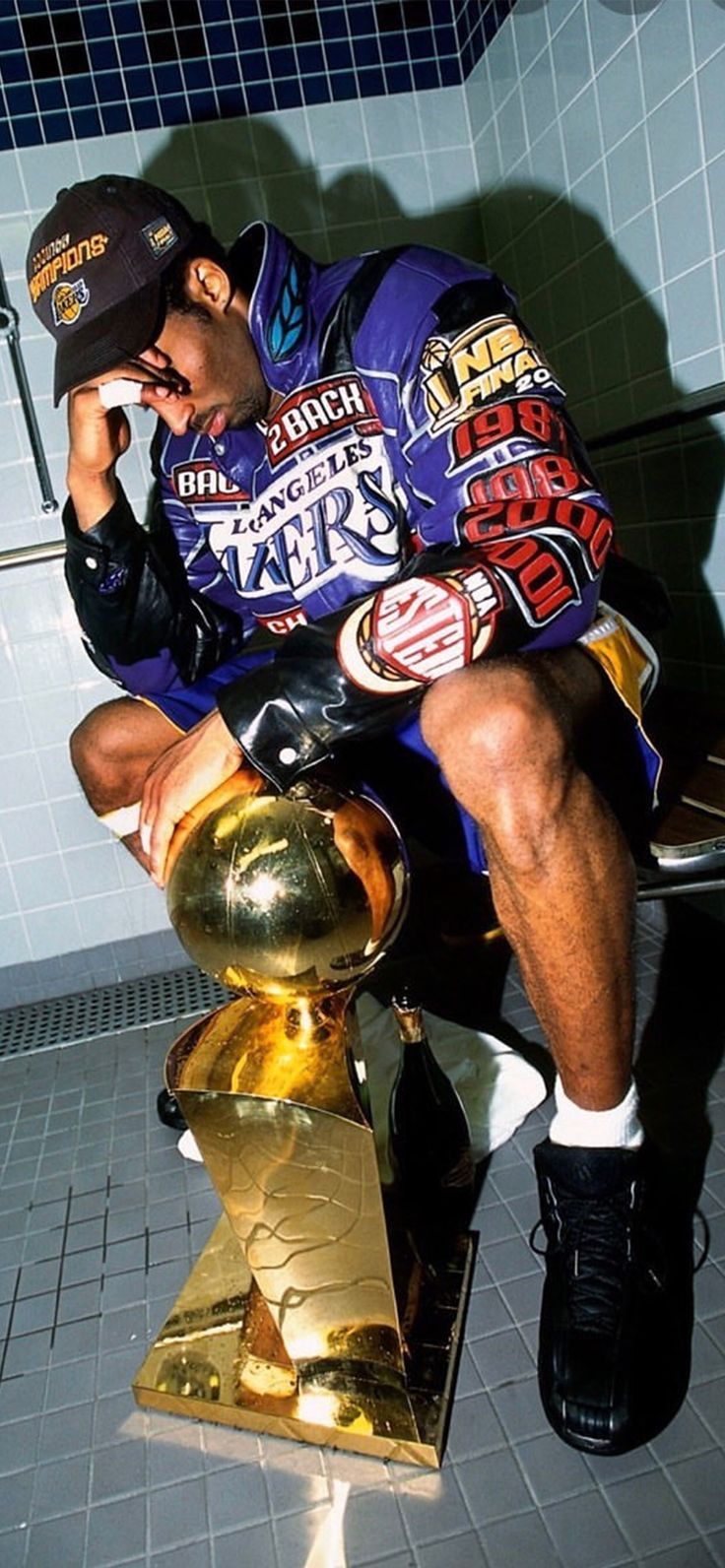 Kobe Bryant sits on a toilet with the NBA championship trophy. - Kobe Bryant