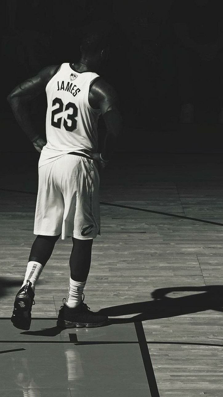 Black and white photo of a basketball player standing on the court. - Lebron James