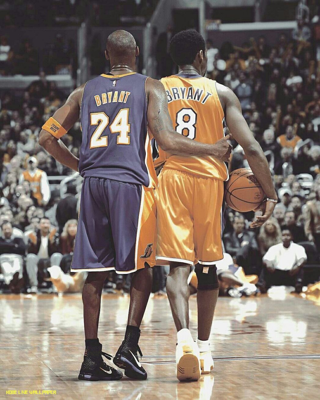 Kobe Bryant standing on the court with his arm around another player - Kobe Bryant
