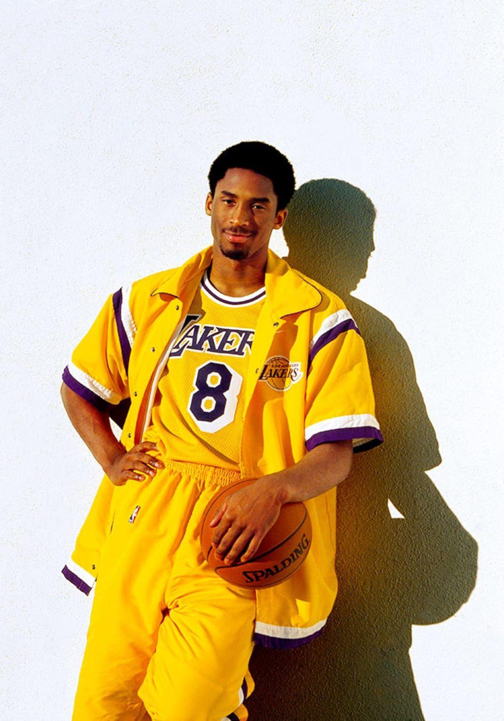 Kobe Bryant in his Lakers jersey holding a basketball. - Kobe Bryant