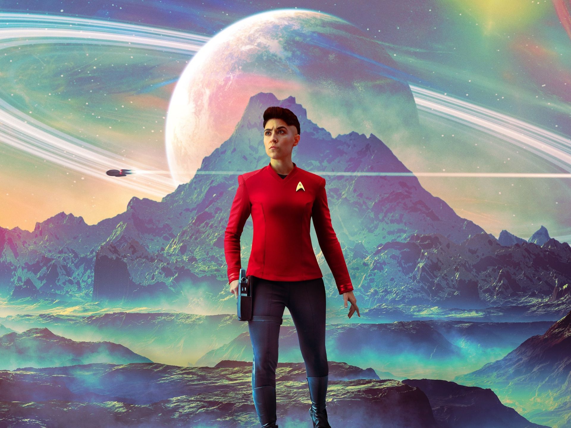 A woman in a Star Trek uniform stands on a hilltop with a planet in the background. - Star Trek