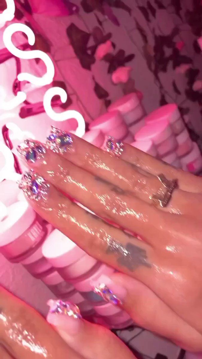 A person with pink nails and glitter on their hands - Nails