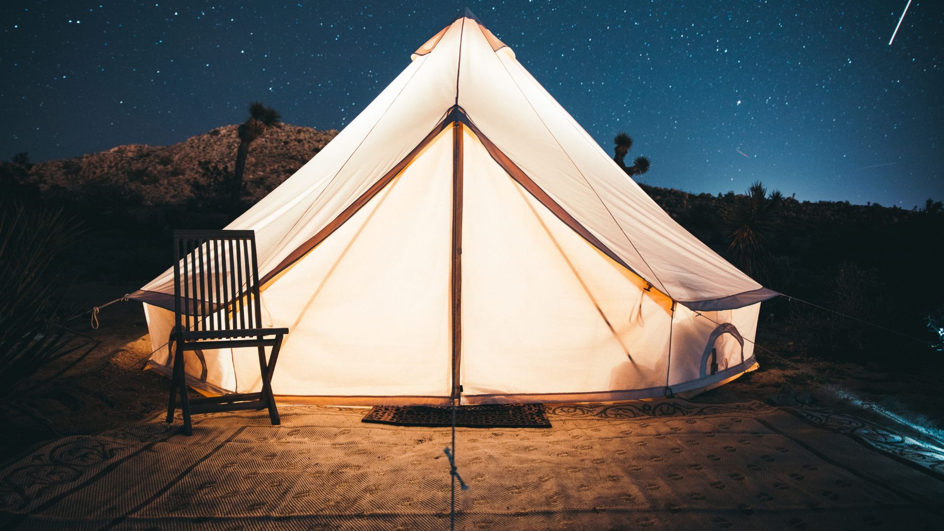 A tent with chairs and stars in the background - Camping