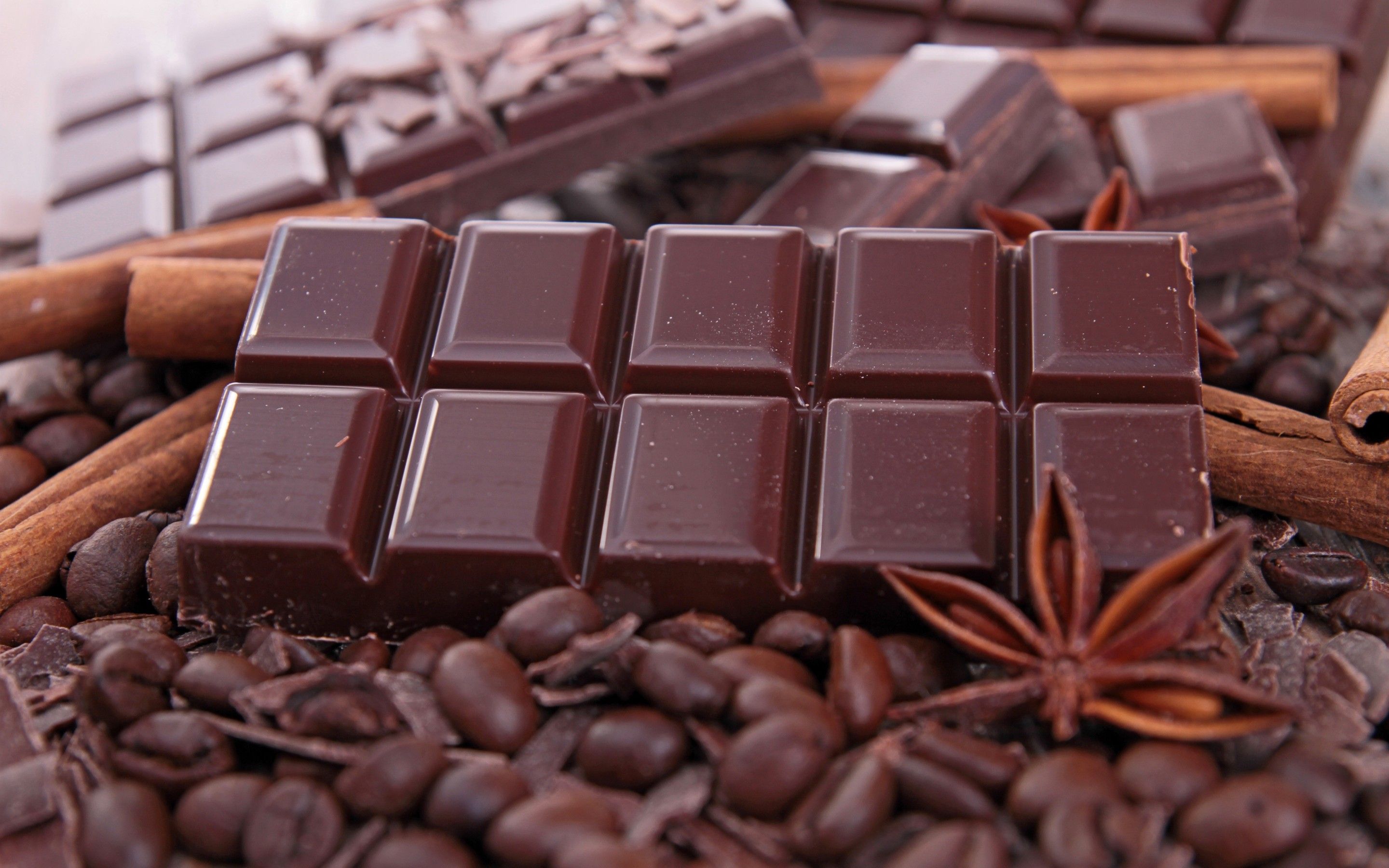 A close up of chocolate bars on top of coffee beans - Chocolate