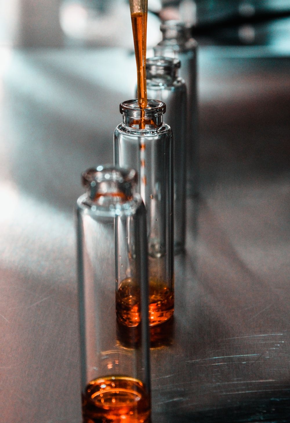 A person pouring liquid into small glasses - Chemistry