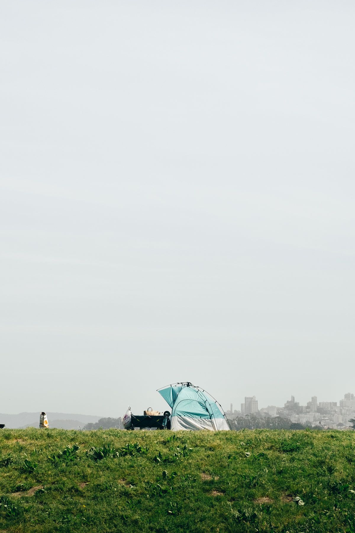 A tent and umbrella on top of grass - Camping