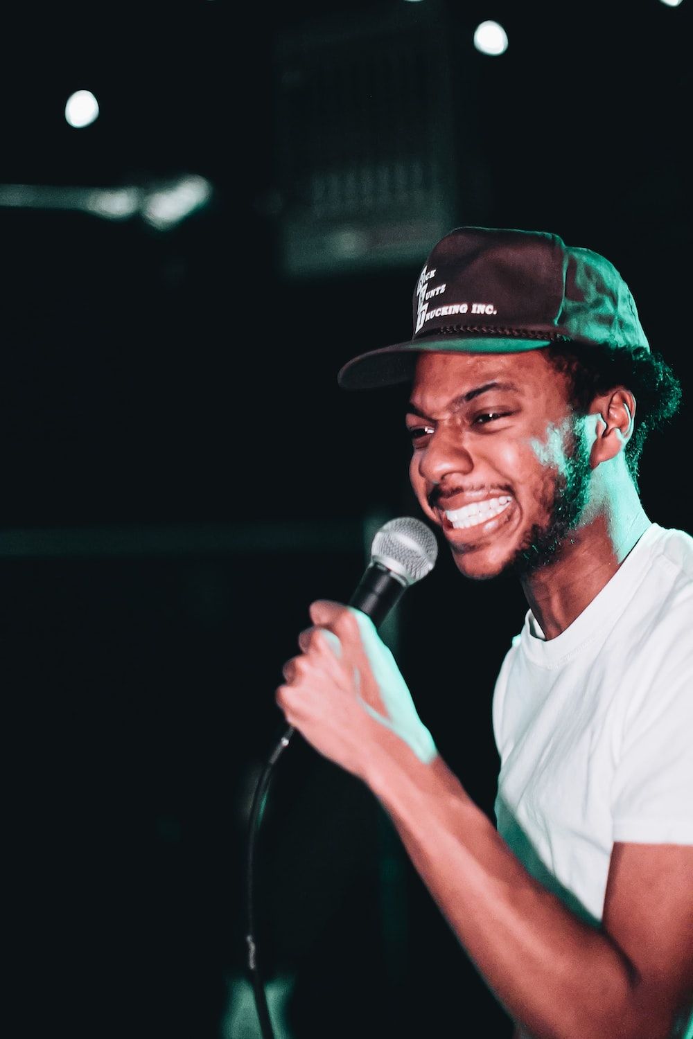 Man In White Crew Neck T Shirt Holding Microphone Photo