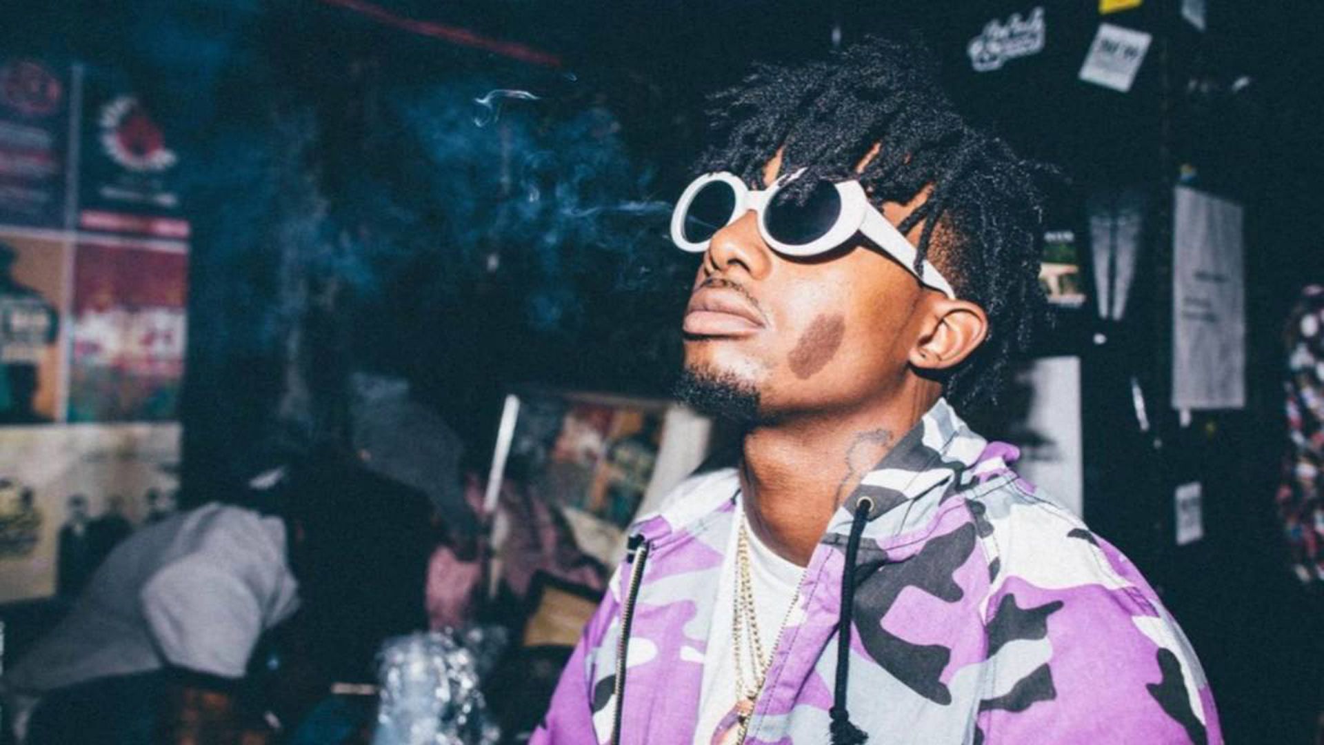 playboi carti is looking up wearing purple and black coat with white tshirt and goggles HD music Wallpaper