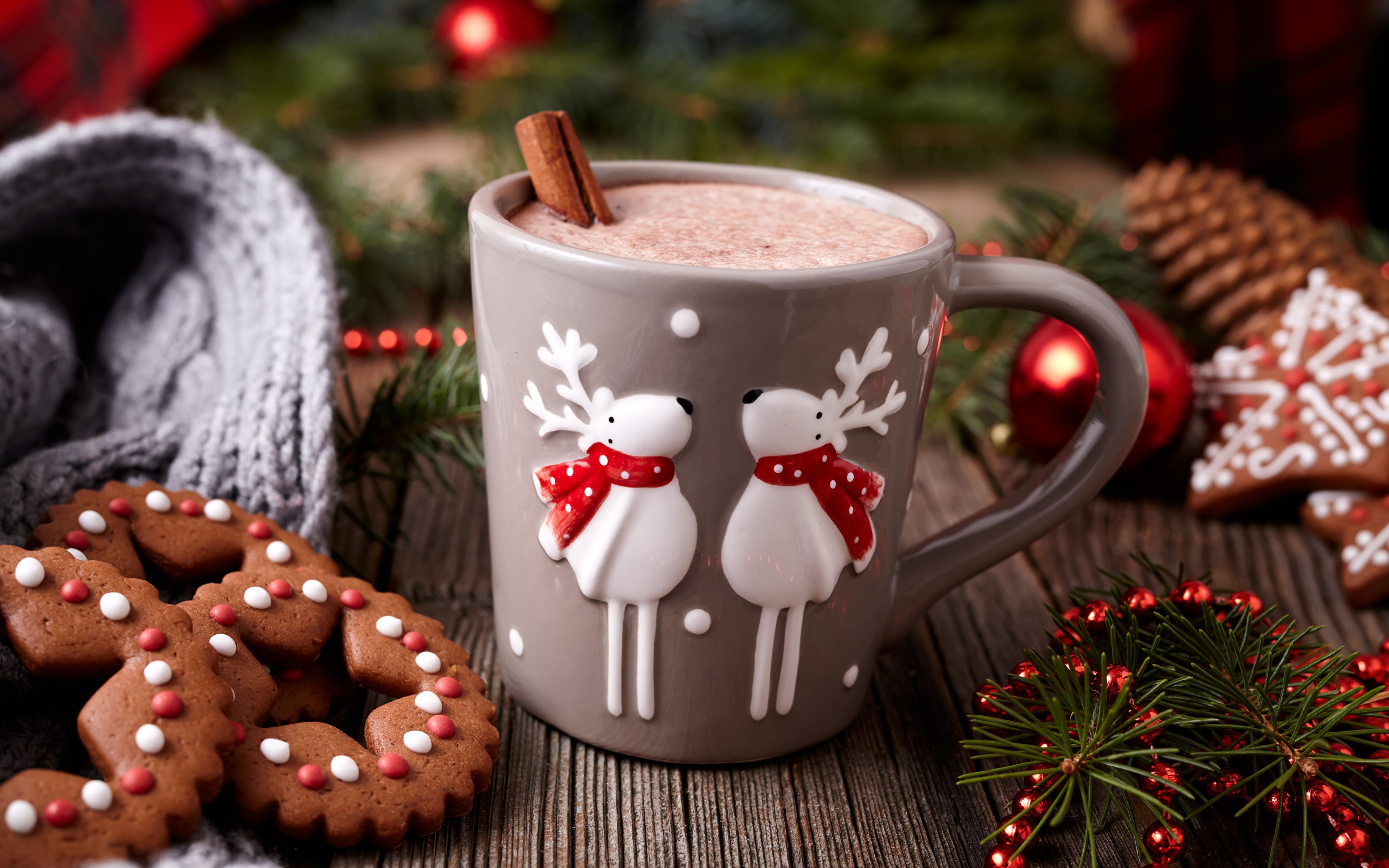 A cup of hot chocolate with reindeer on the side surrounded by Christmas decorations - Chocolate