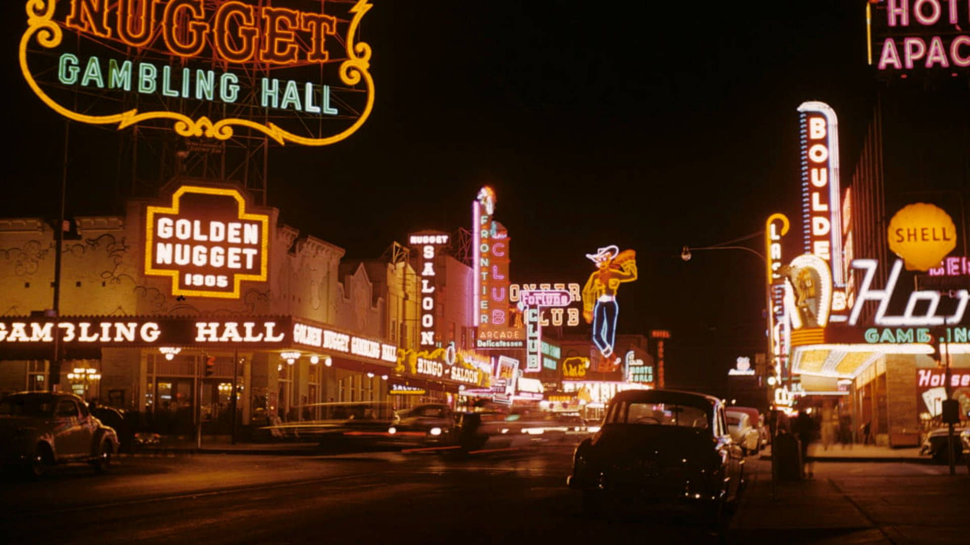 A busy street at night with cars and neon signs - Las Vegas