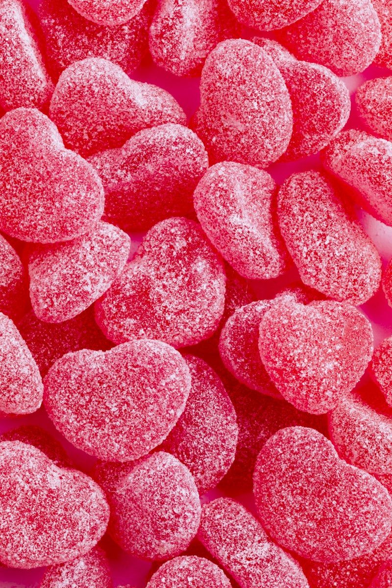 Pink sugared candy hearts on a pink background. - Candy