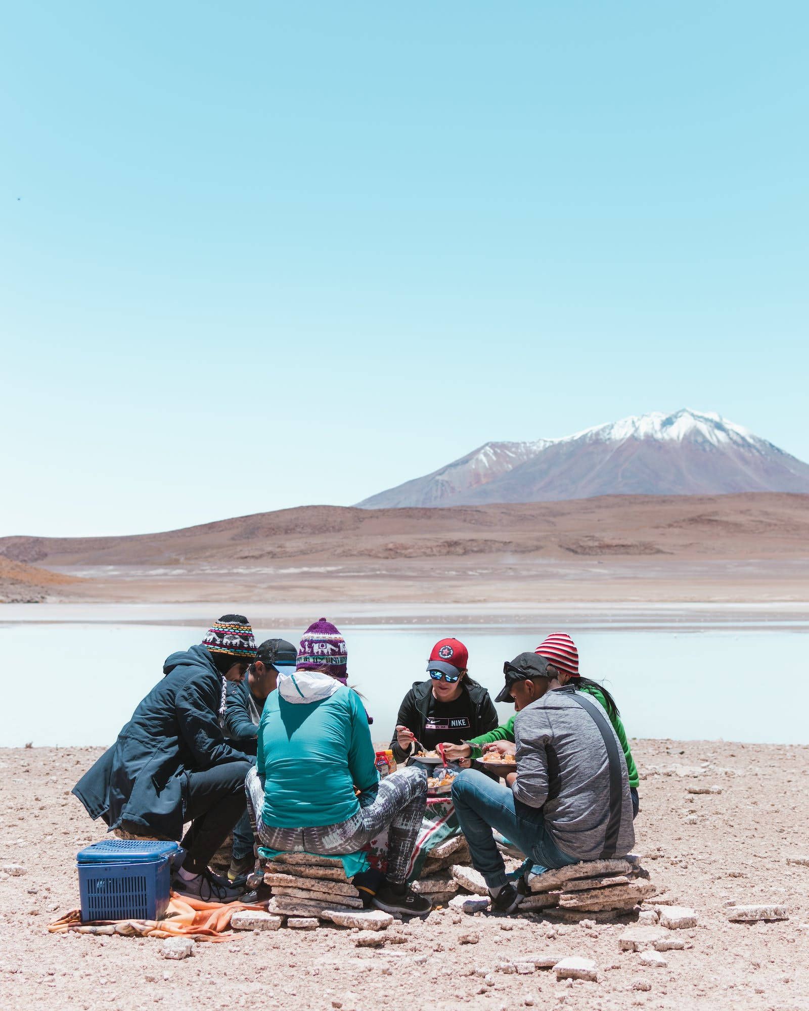 A group of people sitting around on the ground - Camping
