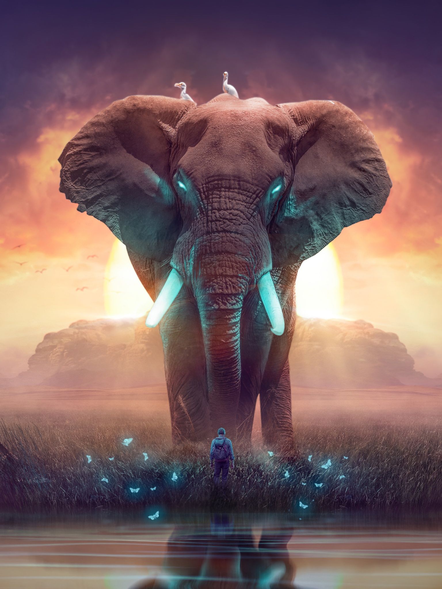 A giant elephant with glowing eyes and tusks, standing in a grassy field with a man in front of it. - Elephant