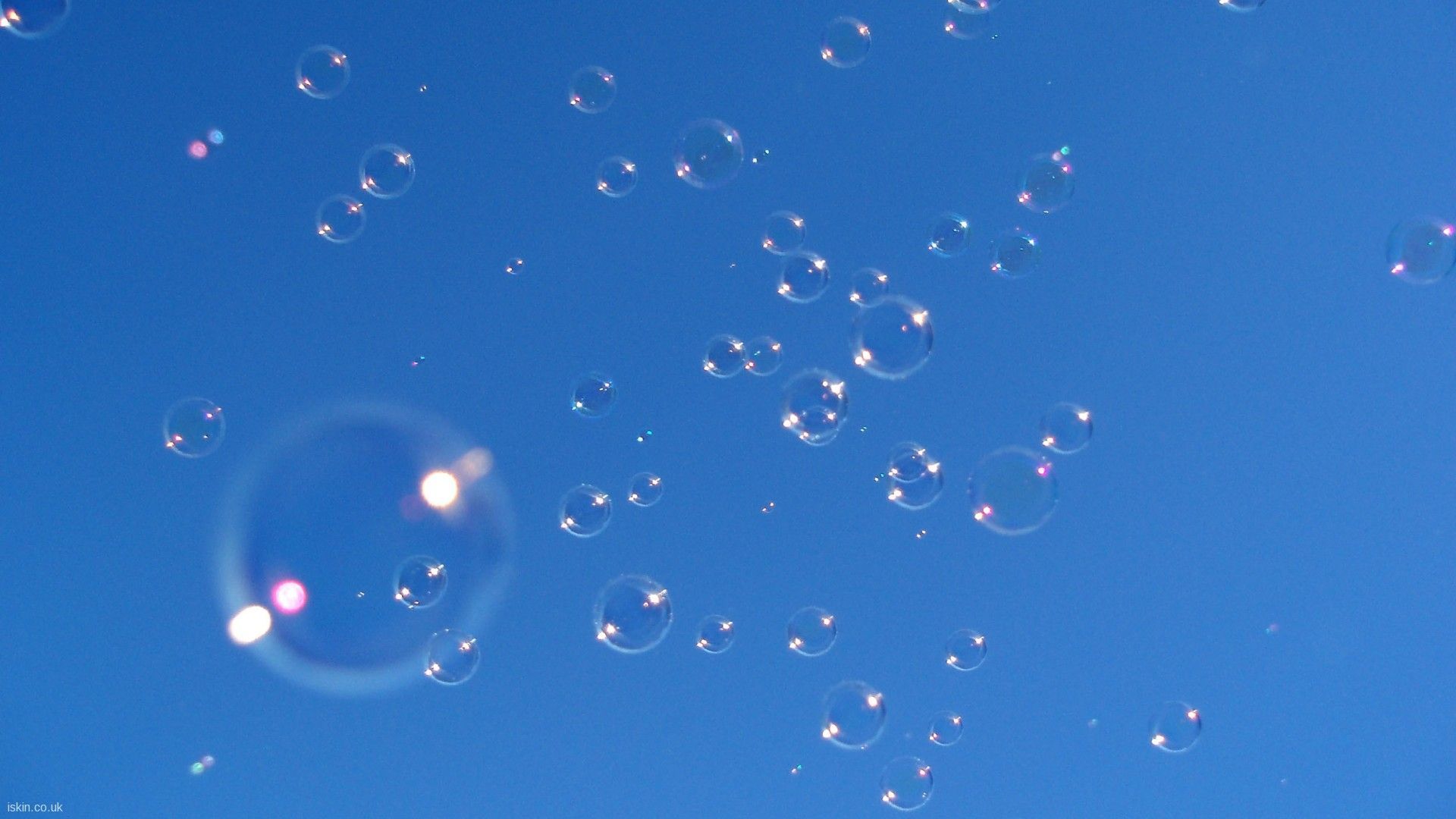 Soap bubbles floating in the air against a blue sky - Bubbles