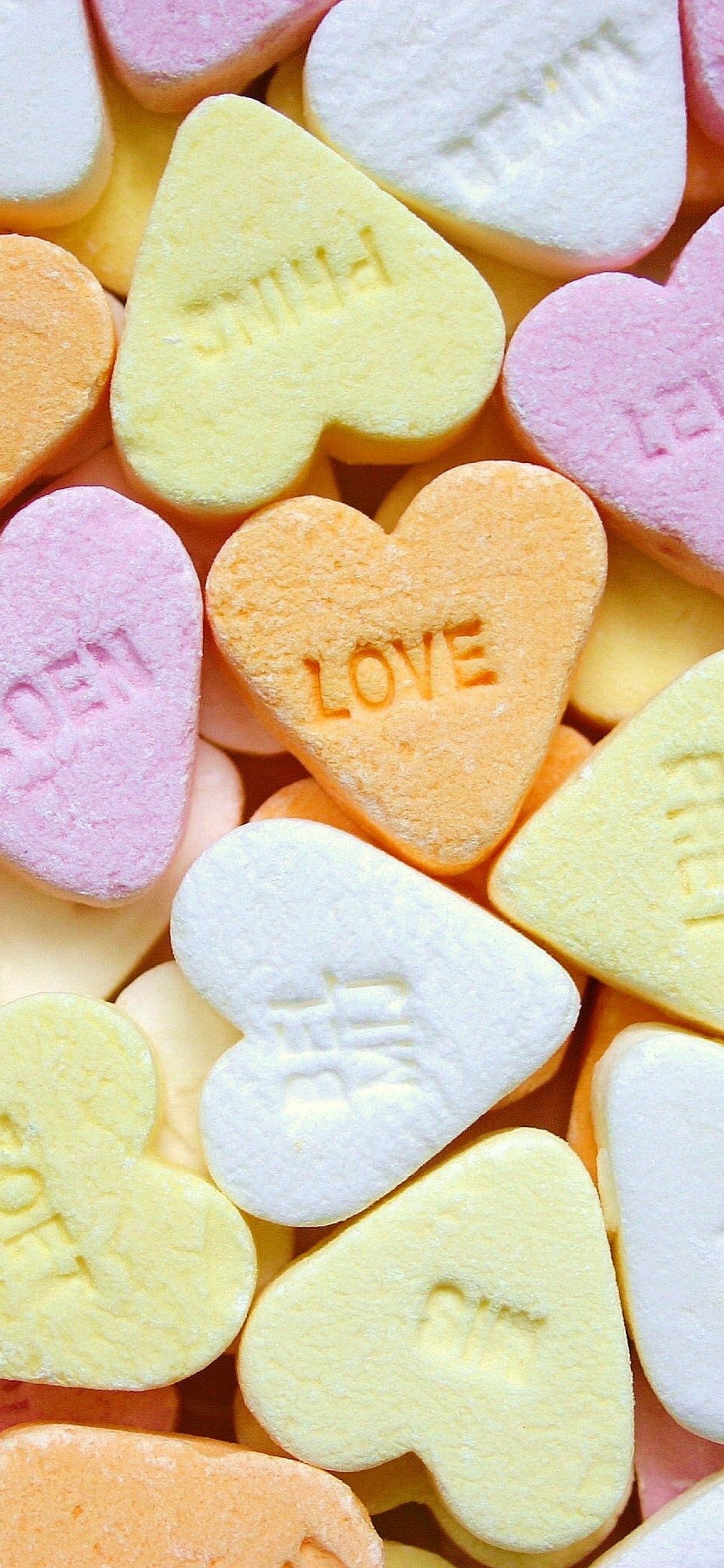 IPhone wallpaper of a pile of candy hearts with one saying love - Candy