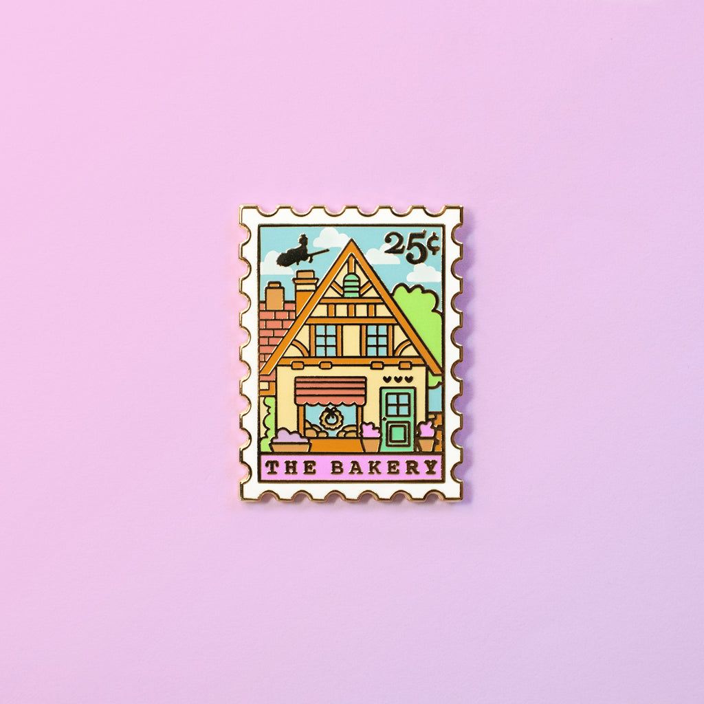 A cute enamel pin of a bakery with a cat in the window. - Bakery