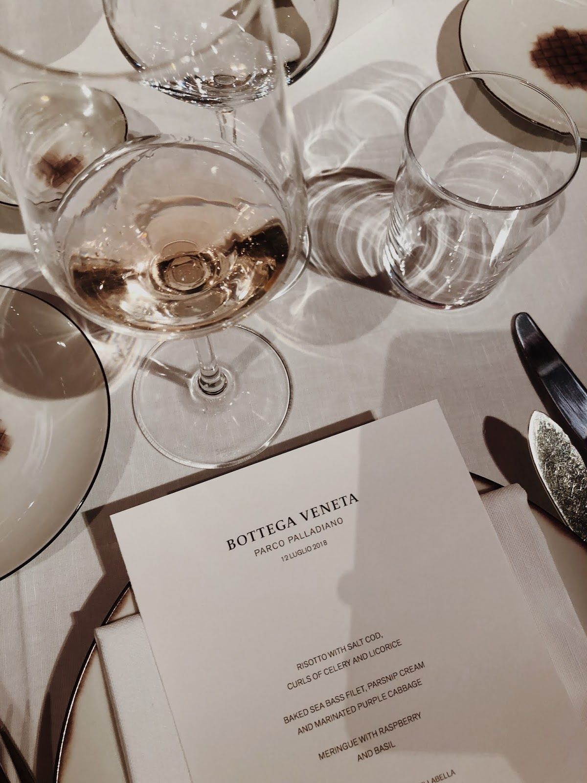 A table with wine glasses and a menu card. - Champagne