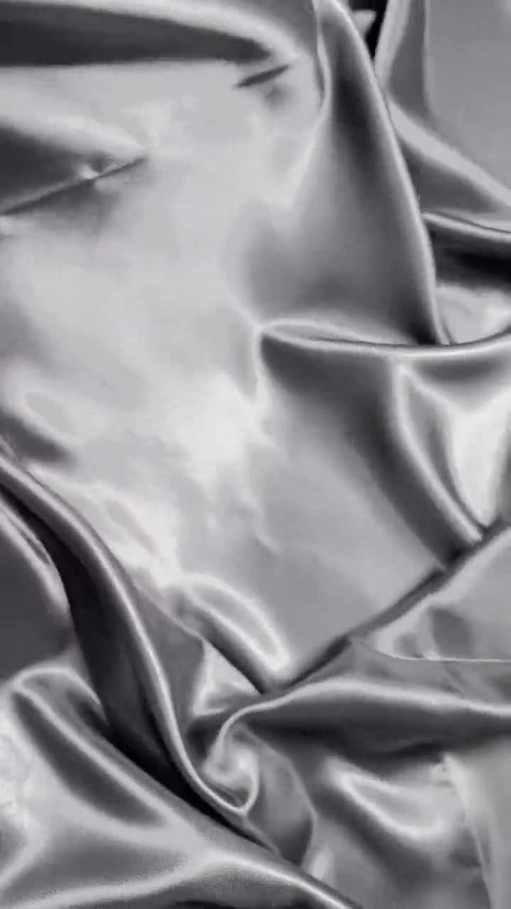 A silver fabric that is being displayed on a white background - Silk