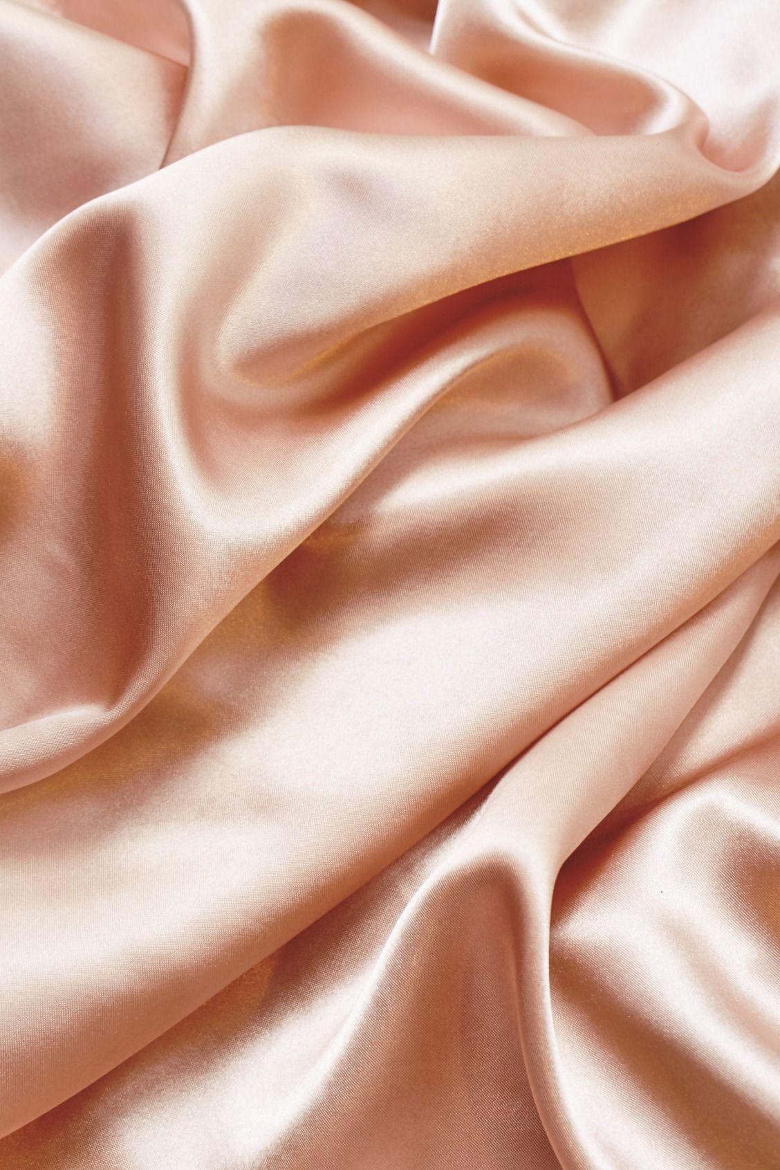 A close up of a pink silk sheet with ripples and folds. - Silk